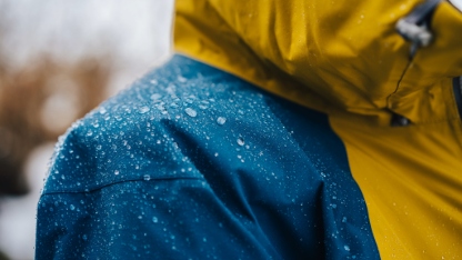 Detail photo of wateproof jacket with water droplets on it.