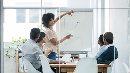 adults in an office room attending a training course with tutor